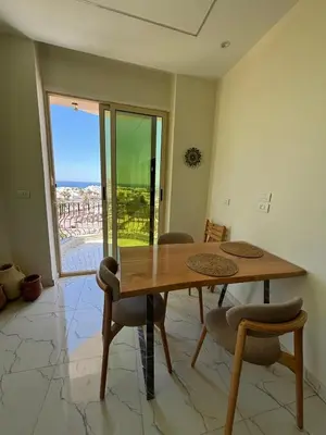 a dining room with a wooden table and chairs at Arabia Sea View in Hurghada