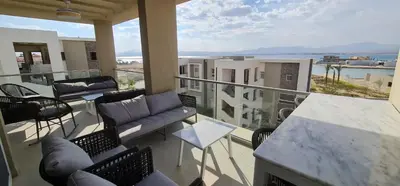a balcony with couches and tables and a view of the ocean at The dune Terrace in Hurghada