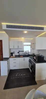 a kitchen with white cabinets and a black stove top oven at The dune Terrace in Hurghada