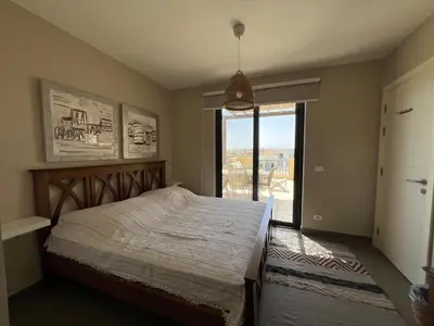 a bedroom with a large bed and a large window at Tawila Luxury 2BR Skyline Loft • Rooftop in Hurghada