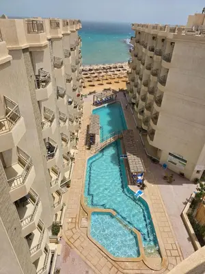 an overhead view of a swimming pool between two buildings at Zafira Apartman in Hurghada