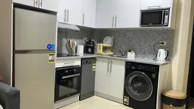 a small kitchen with a washer and dryer at Zafira Apartman in Hurghada