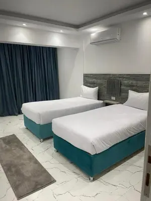 two beds in a hotel room with two beds sidx sidx sidx at live in luxury hotel-style apartment in the heart of the city in Hurghada