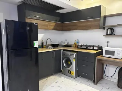 a kitchen with a black refrigerator and a washing machine at live in luxury hotel-style apartment in the heart of the city in Hurghada