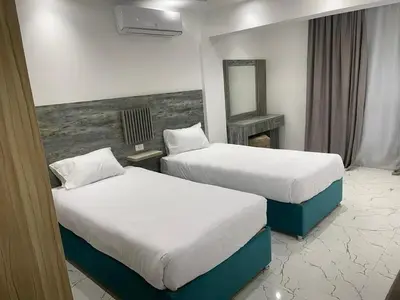 a hotel room with two beds and a mirror at live in luxury hotel-style apartment in the heart of the city in Hurghada