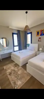 a large bedroom with two beds and a pendant light at Luxury villa in Hurghada