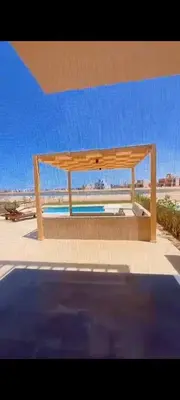 a wooden bench sitting on top of a beach at Luxury villa in Hurghada