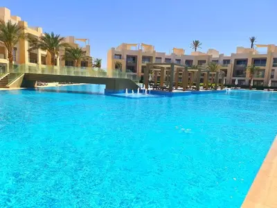 a large pool of blue water in front of buildings at Apartment in El gouna mangrouovy in Hurghada