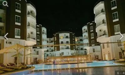 a large apartment building with a swimming pool at night at 2 bed Flat, Hurghada, long&short in Hurghada
