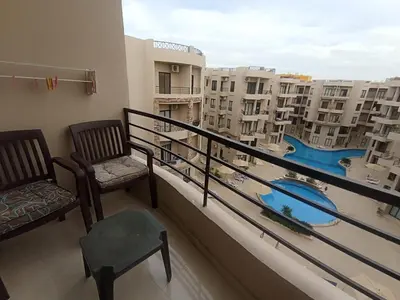 a balcony with two chairs and a view of a pool at 2 bed Flat, Hurghada, long&short in Hurghada