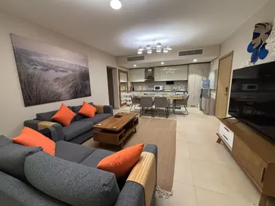 a living room with couches and a table and a kitchen at Apartment in front of the beach in Hurghada