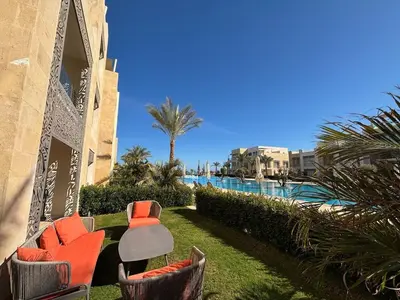 a group of chairs sitting next to a swimming pool at Apartment in front of the beach in Hurghada