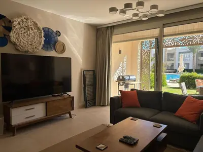 a living room with a couch and a flat screen tv at Apartment in front of the beach in Hurghada