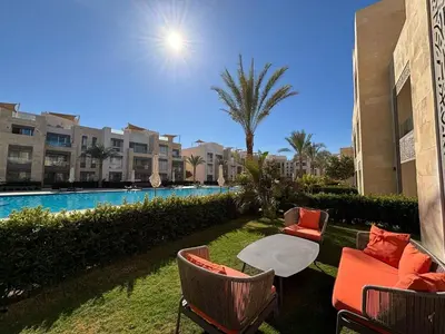 a patio with a table and chairs next to a pool at Apartment in front of the beach in Hurghada