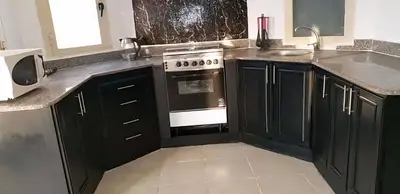 a kitchen with black cabinets and a stove top oven at Regency towers résidence in Hurghada