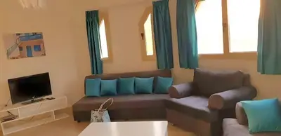 a living room with a couch and a tv at Regency towers résidence in Hurghada