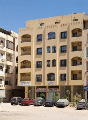 a large building with cars parked in a parking lot at Bayt Hassan S18 - Fabulous Roof top 1 bedroom apartment in Hurghada