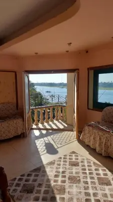 a room with a balcony with a view of the water at Downtown apartment in Luxor