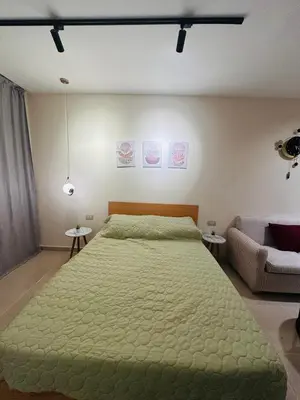 a bedroom with a green bed and a couch at Unique Studio Free access beach in Hurghada