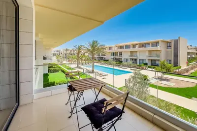 a balcony with a table and chairs and a view of a pool at The Softline Studio G-Cribs in Hurghada
