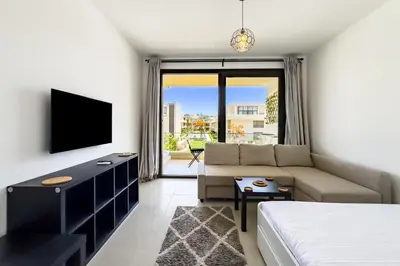 a living room with a couch and a tv at The Softline Studio G-Cribs in Hurghada