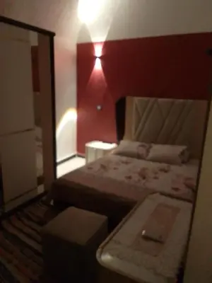 a small bedroom with a bed and a mirror at Neu Student Home in Jazīrat Aswān