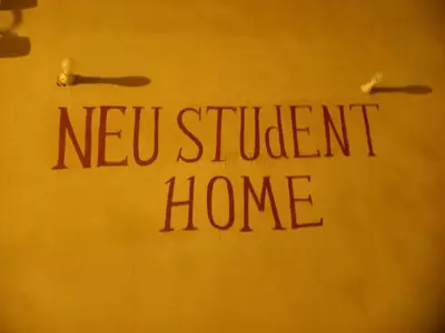 a sign with the words new student home on a wall at Neu Student Home in Jazīrat Aswān
