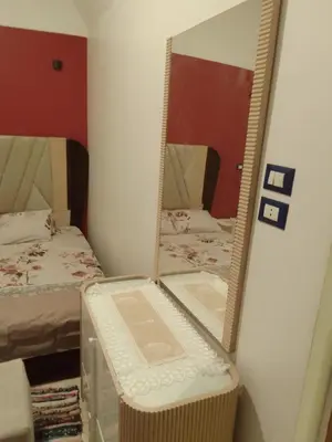 a bedroom with two beds and a mirror at Neu Student Home in Jazīrat Aswān
