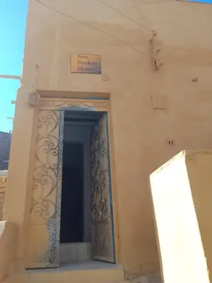 a door to a building with a sign on it at Neu Student Home in Jazīrat Aswān