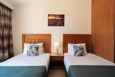 a hotel room with two beds and a table with a lamp at Riviera Aqua Park Resort in Hurghada