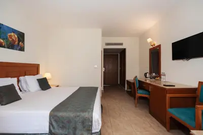 a hotel room with a bed and a desk at Riviera Aqua Park Resort in Hurghada