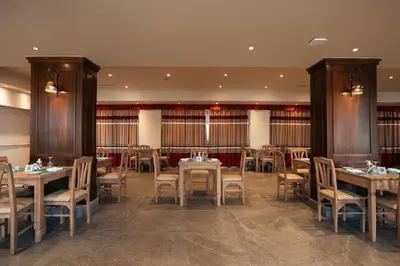 a restaurant with tables and chairs in a room at Riviera Aqua Park Resort in Hurghada