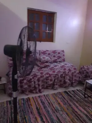 a living room with a couch and a fan at Neu Student Home 2 in Jazīrat Aswān