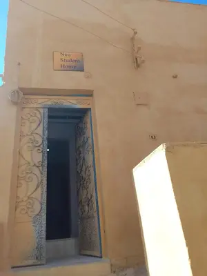 a door to a building with a sign on it at Neu Student Home 2 in Jazīrat Aswān