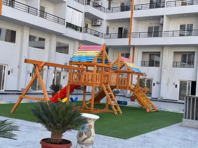 a playground in front of a apartment building at Apartment with private beach 09D in Hurghada