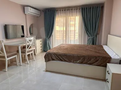 a bedroom with a bed and a desk and a table at Apartment with private beach 09E in Hurghada