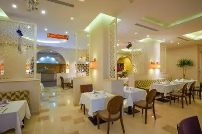 a restaurant with white tables and chairs in a room at Salvatore Rooms All Inclusive -Cornich Street in Hurghada