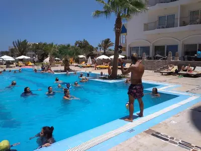 a man standing in the swimming pool at a resort at Salvatore Rooms All Inclusive -Cornich Street in Hurghada