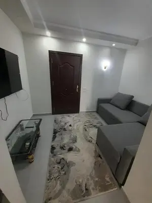 a living room with a couch and a table and a door at شالية في كمباوند سكانديك عرابيا in Hurghada