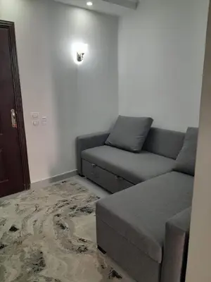 a living room with a couch and a bed at شالية في كمباوند سكانديك عرابيا in Hurghada