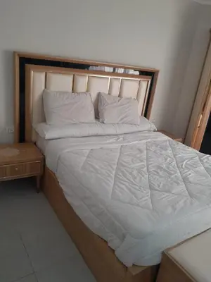 a large bed with white sheets and pillows at شالية في كمباوند سكانديك عرابيا in Hurghada