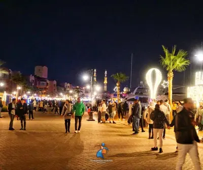 a crowd of people walking on a street at night at Marina Bay Elegance Room Balcony Overlooking Luxury Yachts in Hurghada