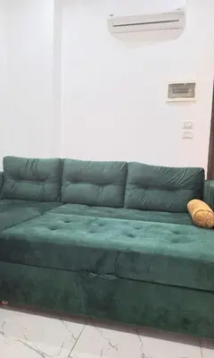 a green couch sitting in a living room at Marina Bay Elegance Room Balcony Overlooking Luxury Yachts in Hurghada