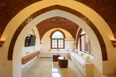a living room with a couch and a brick wall at Desert Rose apartments in Luxor