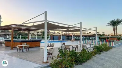a pavilion with tables and chairs and a pool at شالية منتجع سكانديك عرابيا in Hurghada