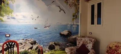 a room with a window with a painting of the ocean at Souzan house in Luxor