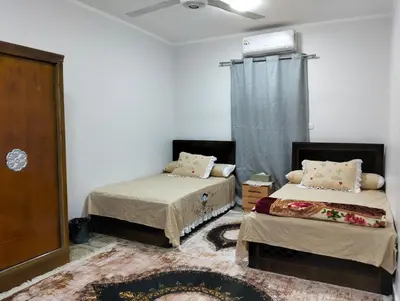a room with two beds in a room with a window at apartment in Hurghada