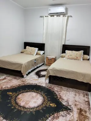 a room with two beds and a rug at apartment in Hurghada