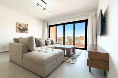 a living room with a couch and a large window at Cool & Curated 1BDR Kamaran El Gouna in Hurghada