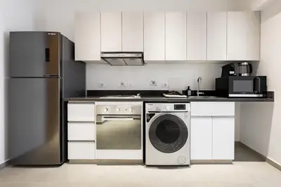 a kitchen with a stainless steel refrigerator and a dishwasher at Cool & Curated 1BDR Kamaran El Gouna in Hurghada